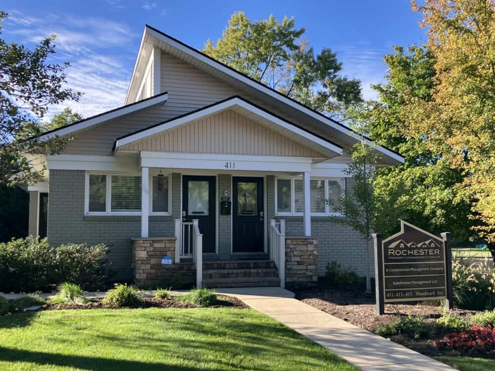 Modern suburban duplex with well-maintained landscaping and a welcoming porch, managed by Rochester Property Management Group, located at 411 Woodward Ave. in Rochester, NY.