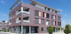 Modern multi-story residential building with brick exterior, spacious balconies, and contemporary design, representing professional property management services in Rochester, NY.