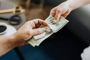 $20 bills being exchanged in a financial transaction, representing property management payments or rent collection at Rochester Property Management Group, Rochester NY.