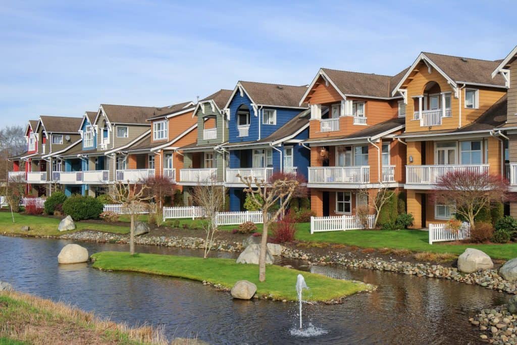 Colorful multi-story apartment complex with a water feature and manicured landscaping in Rochester.
