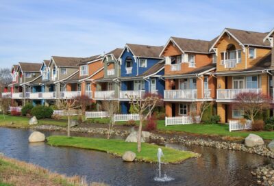 Colorful multi-story apartment complex with a water feature and manicured landscaping in Rochester.