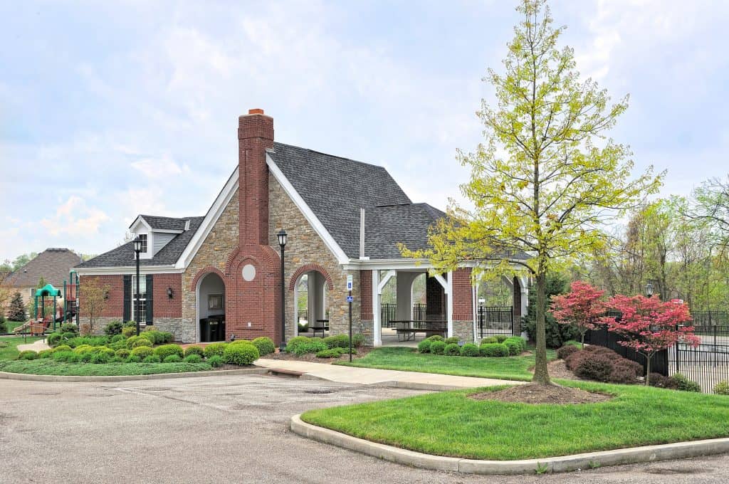 Modern clubhouse and outdoor community space at Rochester Property Management Group in Rochester, NY, featuring landscaped gardens, a picnic area, and recreational amenities.