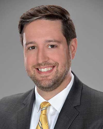 Experienced property manager smiling in professional headshot for Rochester Property Management Group team member.