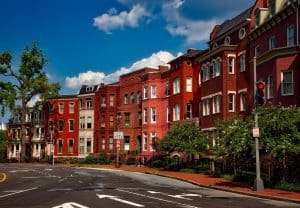 Red brick residential row houses in Rochester with a vibrant neighborhood atmosphere, ideal for property management services, rentals, and real estate investment.